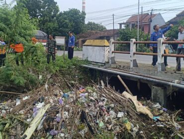 Forkopimcam Sluke bersama dinas terkait dari kabupaten dan provinsi meninjau lokasi sungai yang tersumbat sampah, Selasa (17/6/2025). (Foto: rembangsepekan).