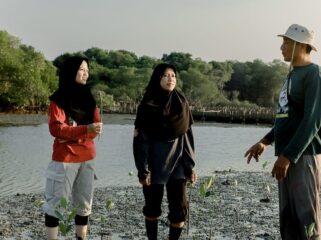 Ketua Kelompok Mangrove Sidodadi Maju, Wachana Ari Purwanto bersama dua pemuda tengah menanam bibit mangrove di Pantai Desa Pasarbanggi, Rembang, baru-baru ini. (Foto: rembangsepekan.com)